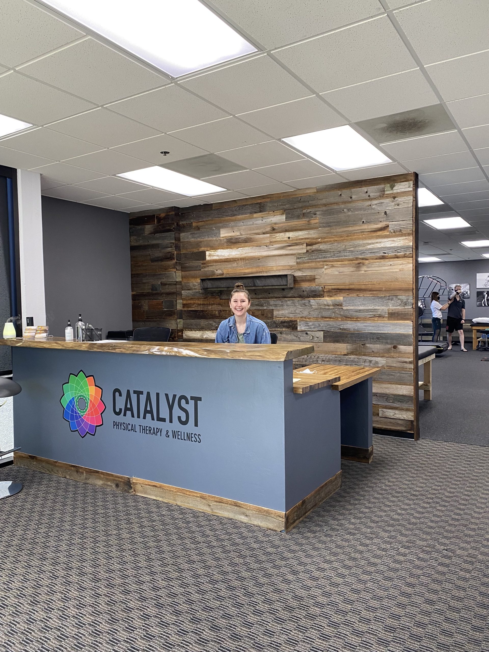 Catalyst 4S Ranch reception with reclaimed wood feature wall and the Catalyst flower logo