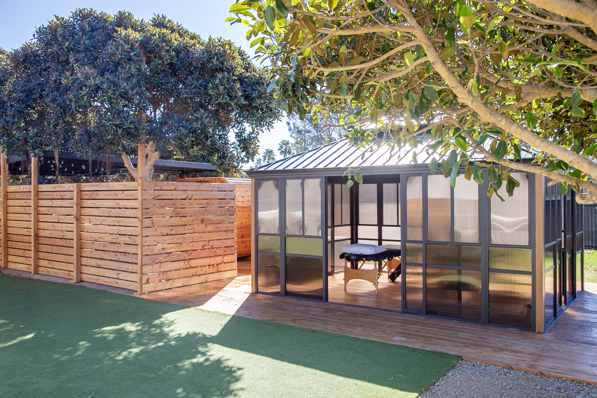 Catalyst Point Loma outdoor treatment cabana — wood deck, polycarbonate panels, surrounded by trees
